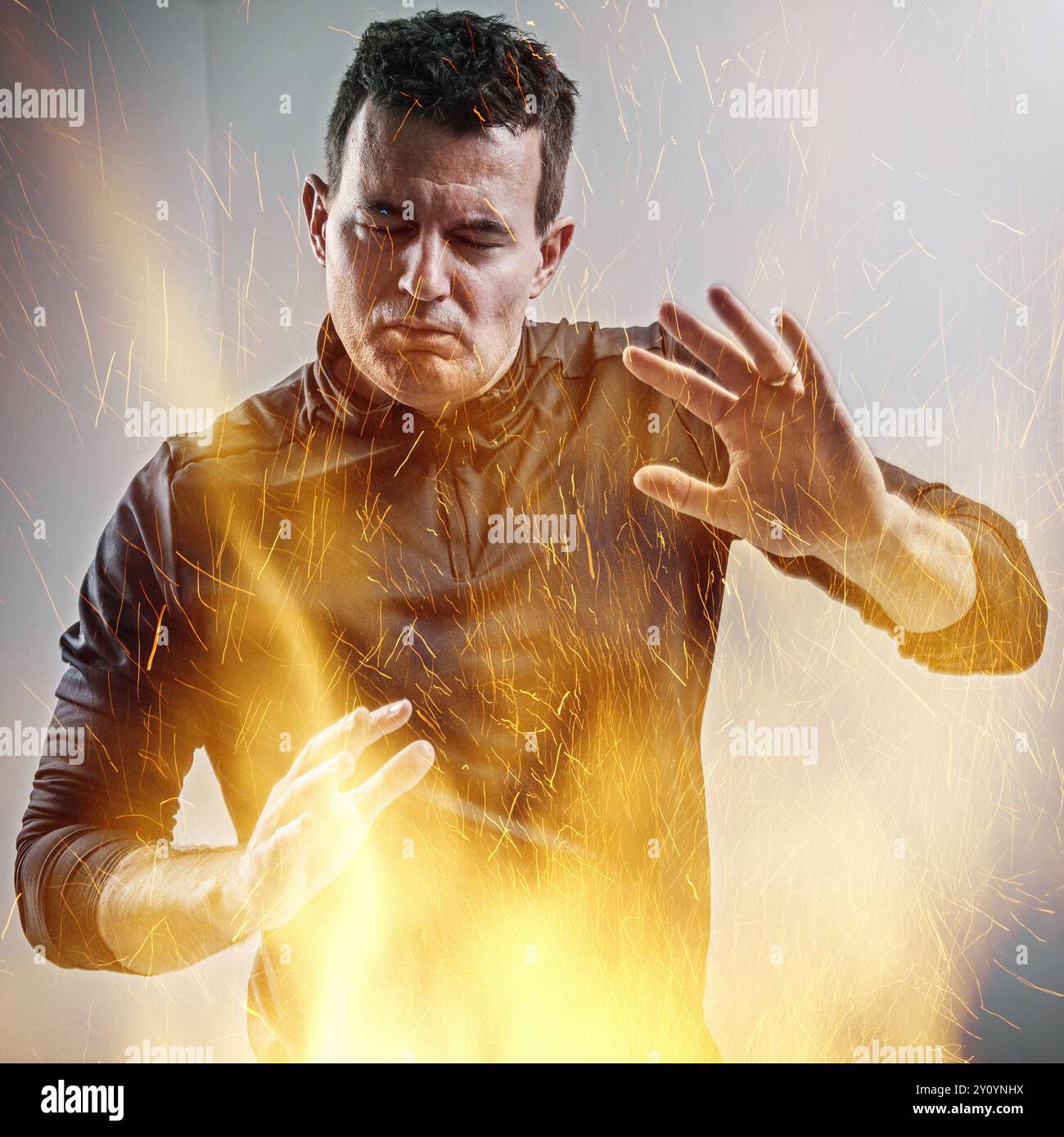 Ein Mann, der die Hände als Schutz vor einer Explosion hält Stockfoto