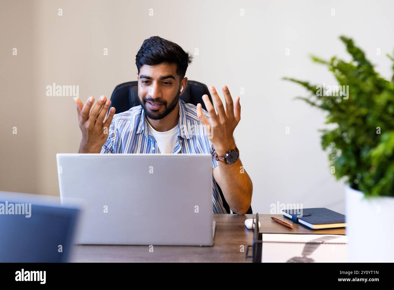 Mit Laptop, indischer Mann über die Arbeit in einem virtuellen Meeting am Bürotisch Stockfoto