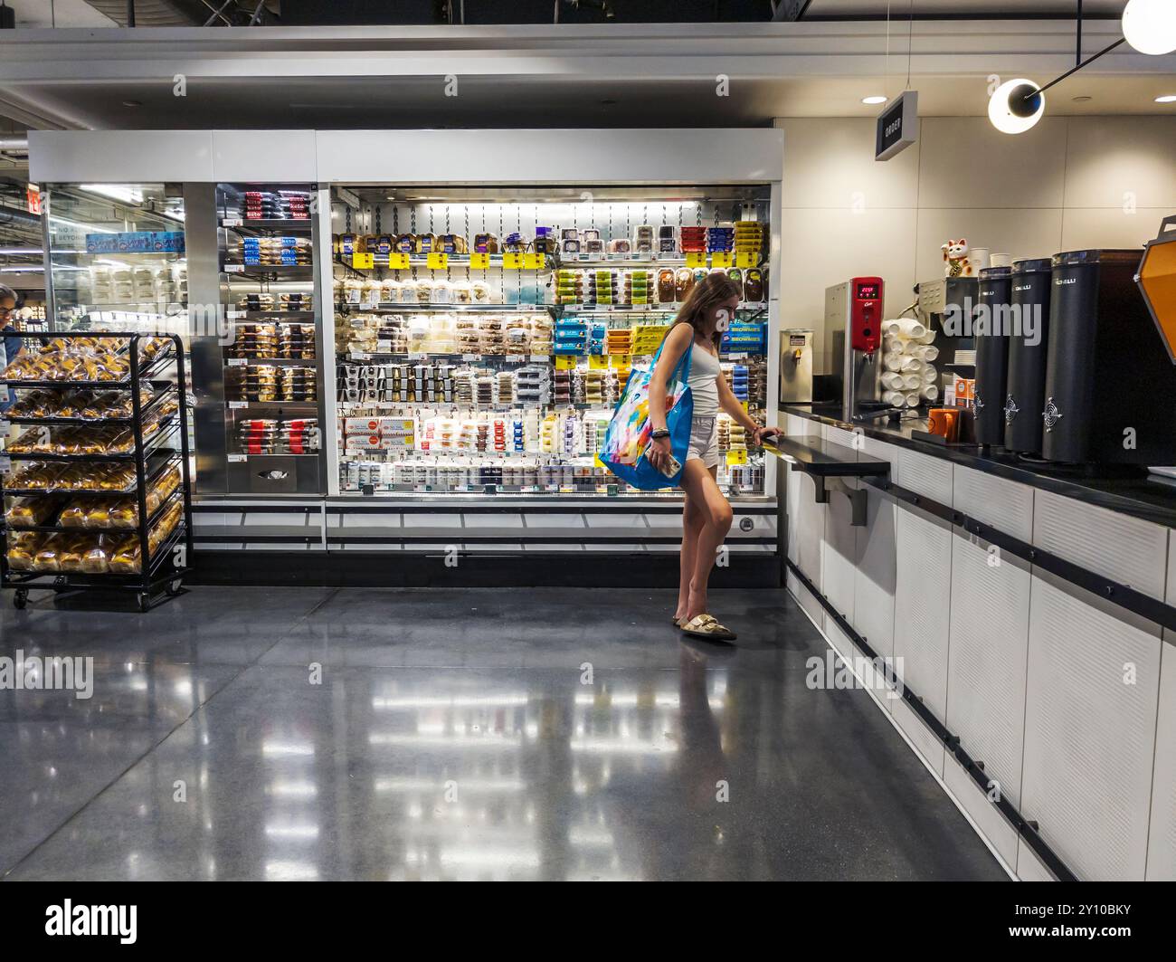 Eine Frau wartet am Montag, den 26. August 2024, auf ihre Bestellung, die in einem Cafe Grumpy auf einem Whole Foods Market in Manhattan West in New York zubereitet wird. Die Inflation ist nach Berichten schwinden und ist weniger ein politischer Brennpunkt als vor einigen Monaten. (© Richard B. Levine) Stockfoto