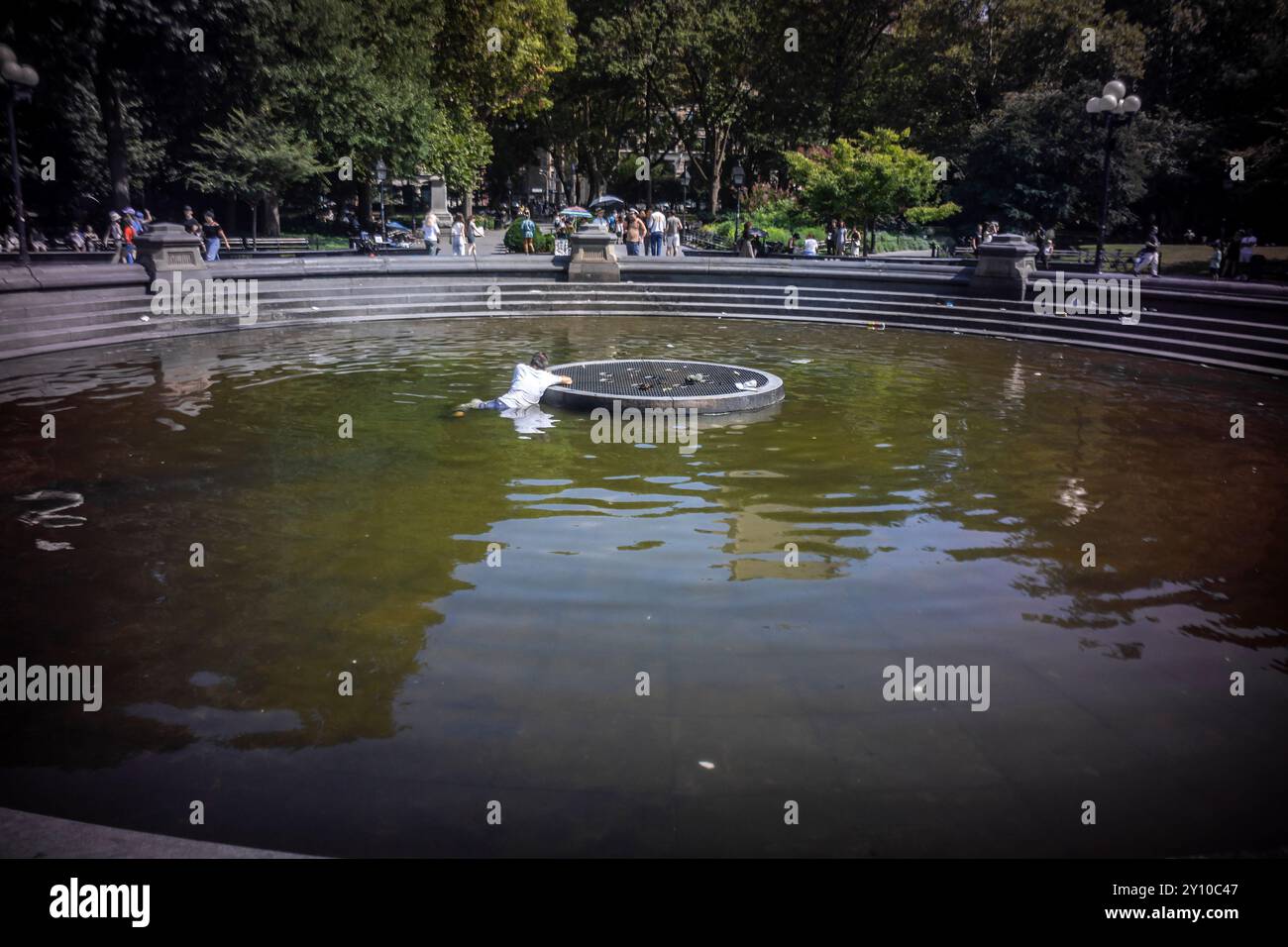 Schlafender Obdachloser kühlt sich am 18. August 2024 im Brunnen im Washington Square Park in Greenwich Village in New York ab. (© Richard B. Levine) Stockfoto