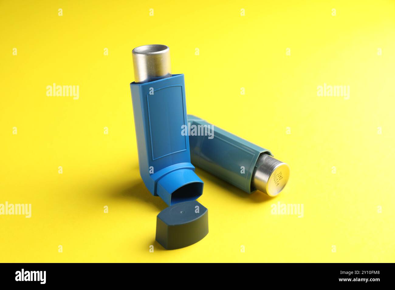 Atemprobleme. Zwei Asthma-Inhalatoren auf gelbem Hintergrund Stockfoto
