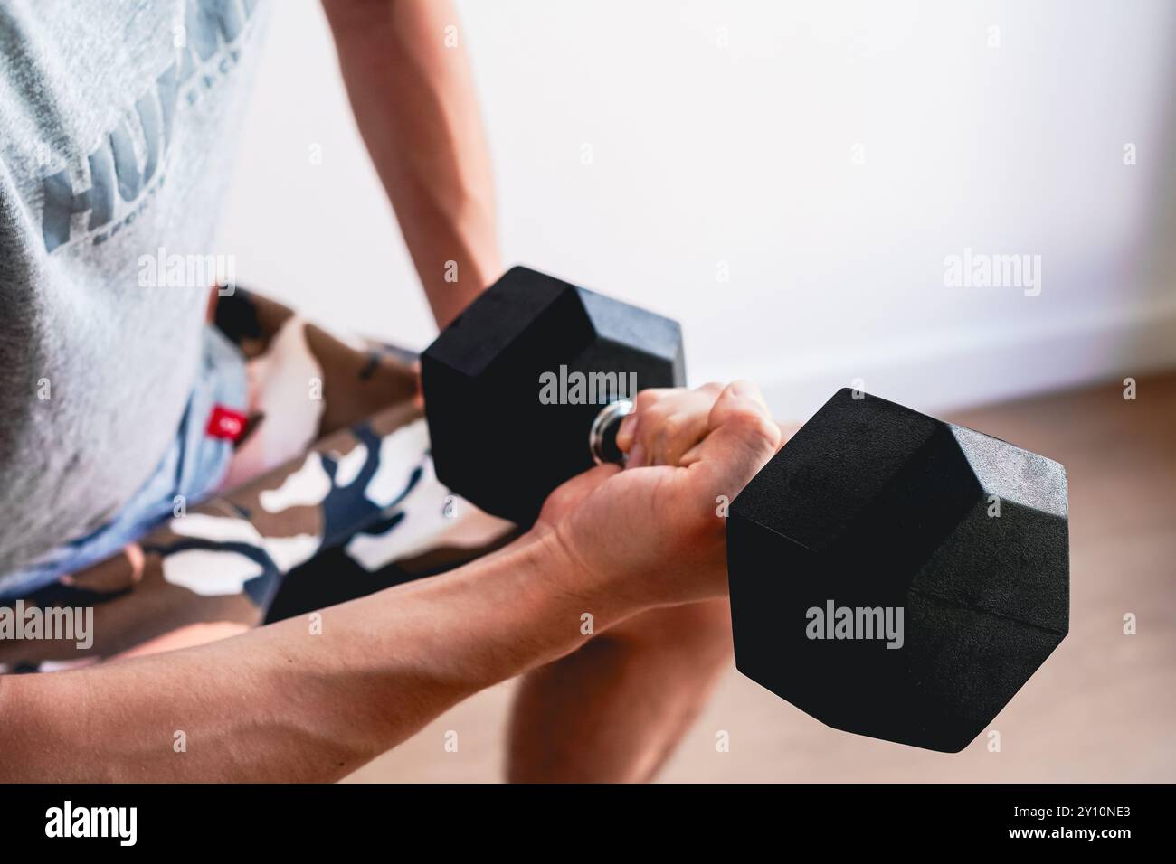 Mann, der zu Hause Krafttraining mit Kurzhanteln macht Stockfoto