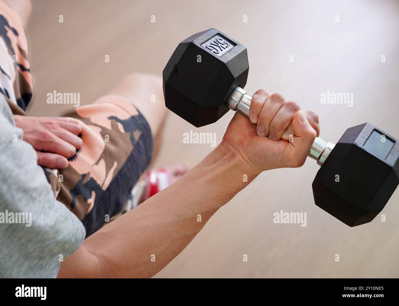 Mann, der zu Hause Krafttraining mit Kurzhanteln macht Stockfoto