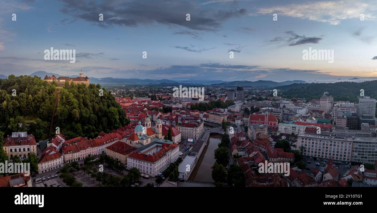 Blick aus der Vogelperspektive auf das Zentrum von Ljubljana Slowenien mit historischen Gebäuden, roten Dachhäusern auf dem Hügel, Kirchen in der slowenischen Hauptstadt Sonnenuntergang farbenfrohe s Stockfoto