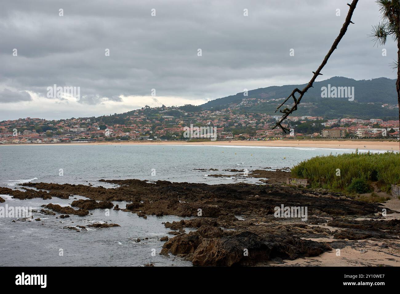 Blick von Montelourido aus, Blick auf Playa América und das charmante Küstendorf Panxón in Galicien, Spanien. Im Vordergrund steht ein auffälliger Stockfoto