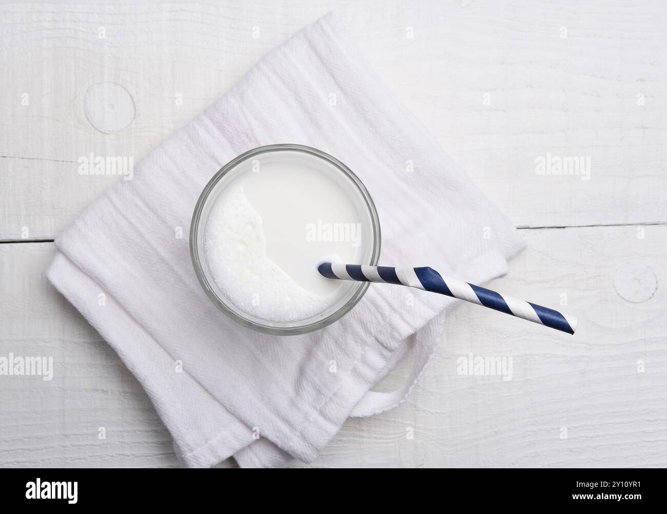 Hochwinkelansicht eines Glases Milch und eines Trinkstrohs. Stockfoto