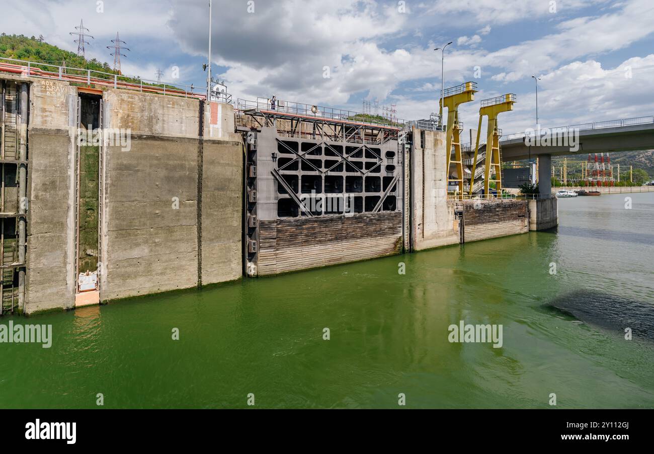Massive Schleusentore und grünes Wasser am Wasserkraftdamm Stockfoto