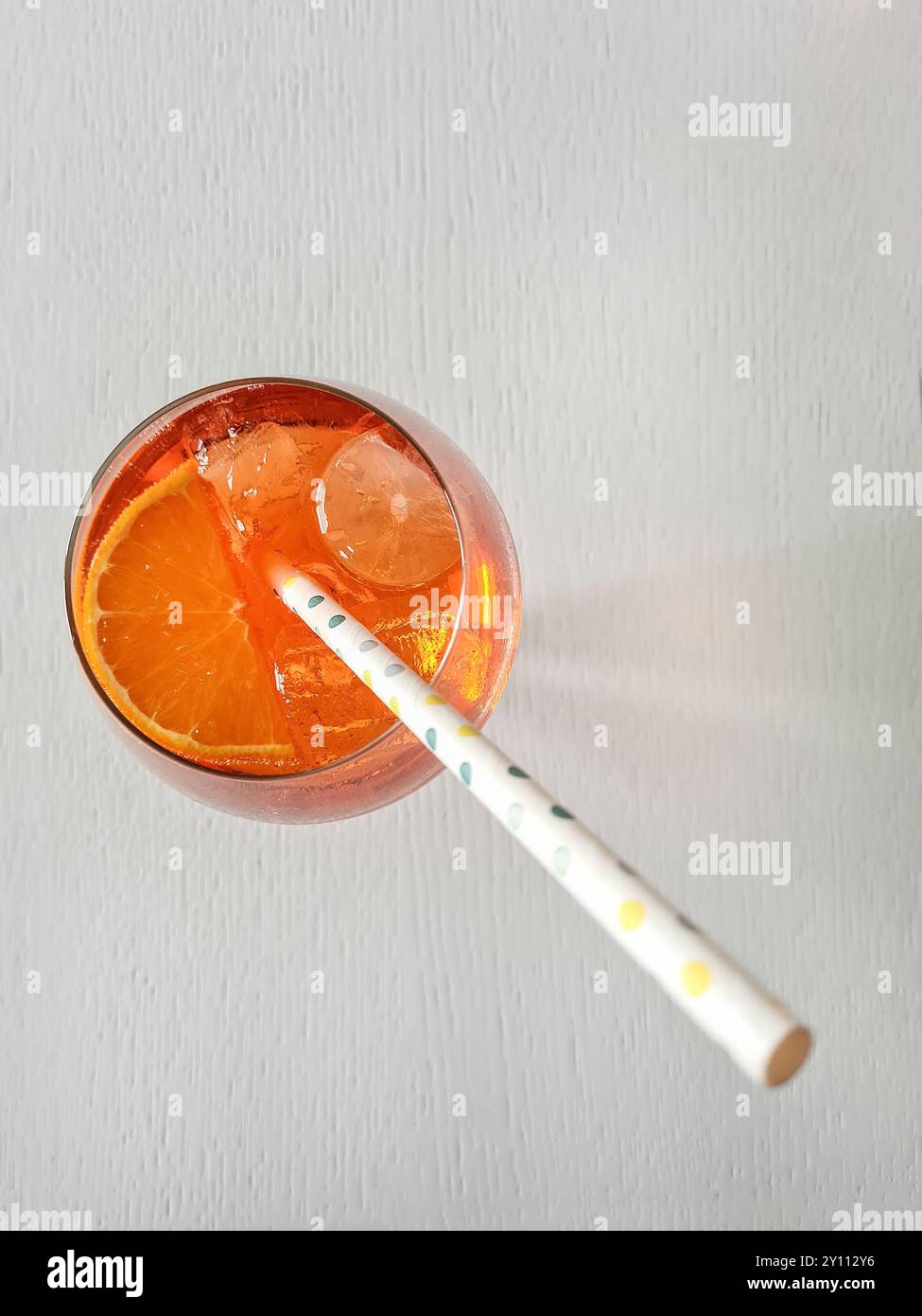 Ein alkoholfreies Getränk mit Stroh, Eiswürfeln und Orangenscheibe im Glas, Erfrischung im Sommer Stockfoto