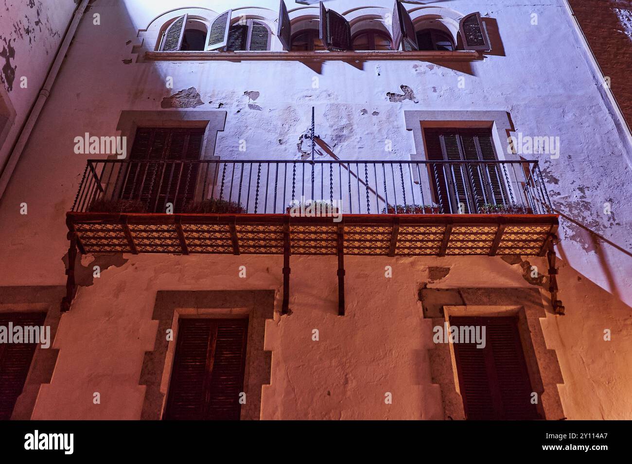 Sitges, Barcelona - 04. September 2024: Nächtlicher Blick auf ein traditionelles Gebäude in Sitges mit architektonischen Details, die durch die Umgebungsbeleuchtung hervorgehoben werden. Ideal Stockfoto