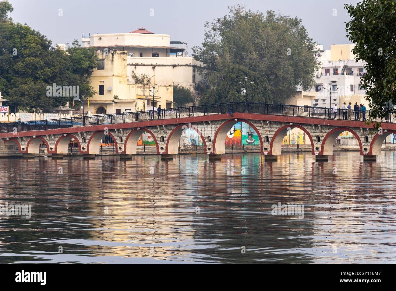 Ein ruhiger Vormittag an Udaipur's historischer Bogenbrücke über dem ruhigen Wasser des Sees wird in Udaipur rajasthan india aufgenommen. Stockfoto