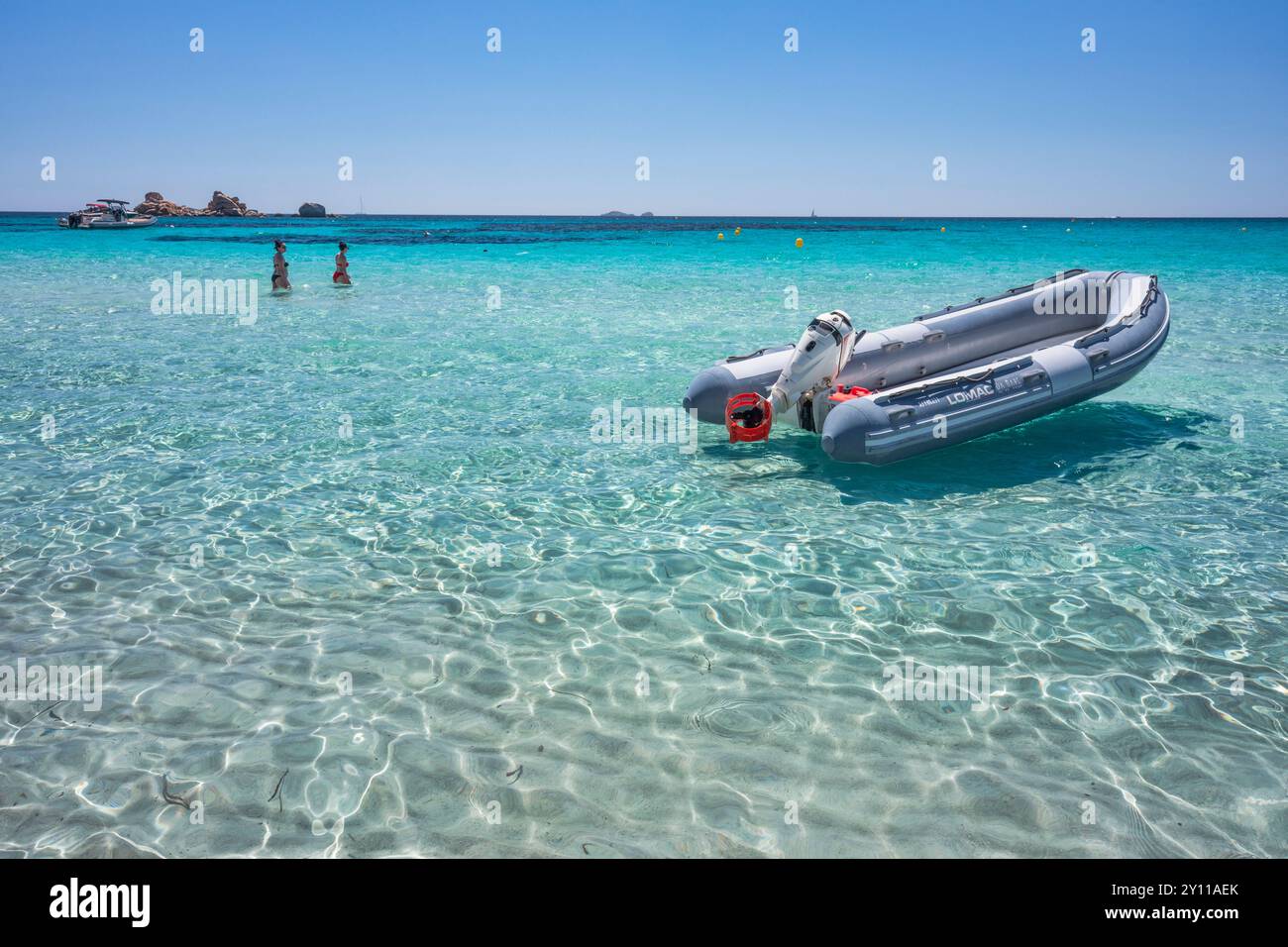 Motorboot vor Anker am Strand von La Folaca, transparentes und kristallklares türkisfarbenes Wasser. Porto Vecchio, Südkorsika, Frankreich Stockfoto