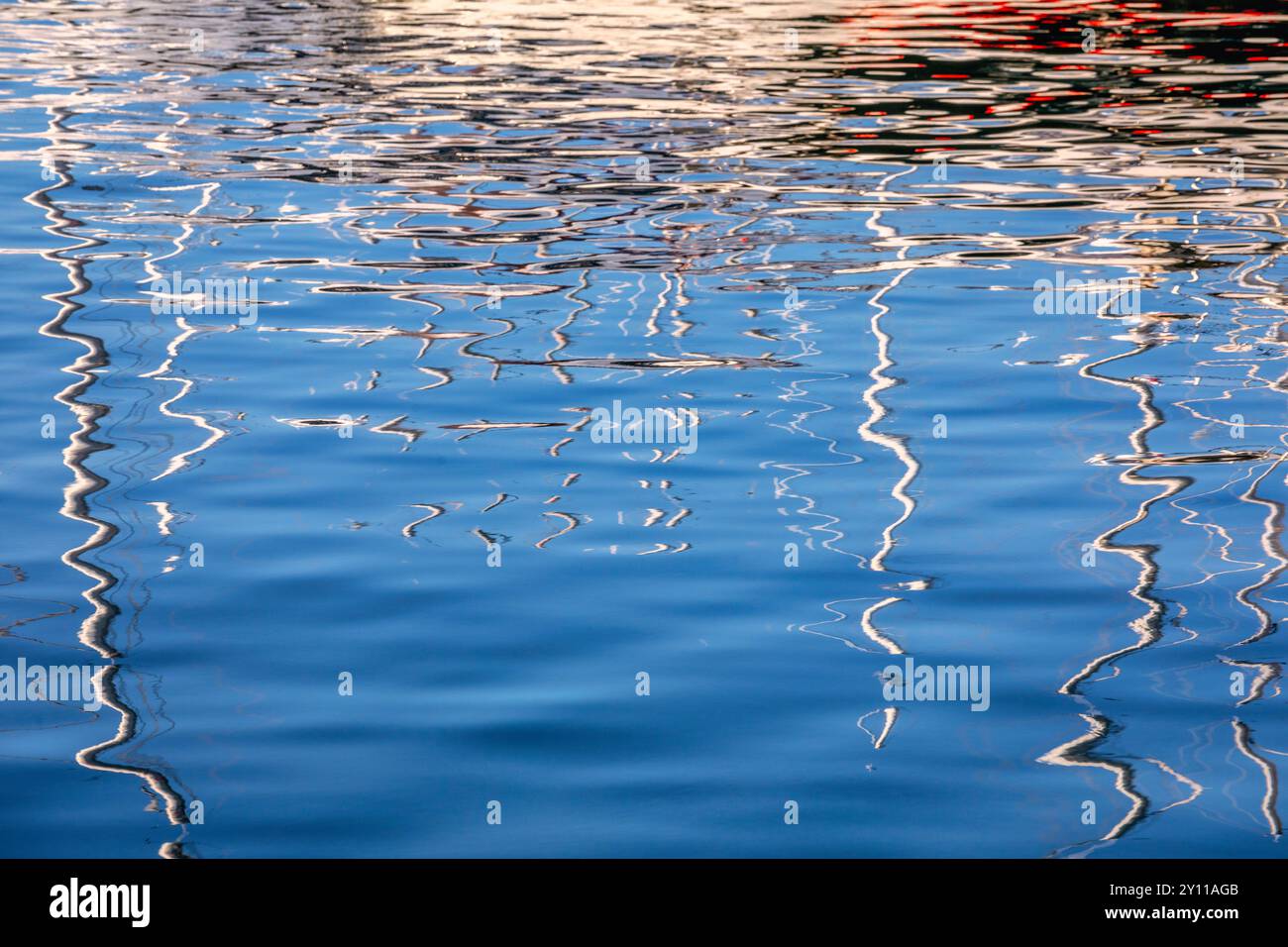 Die Masten der Boote, die im Yachthafen vertäut waren, spiegelten sich im leicht beweglichen Wasser. Porto Vecchio, Corse-du-Sud, Korsika, Frankreich Stockfoto