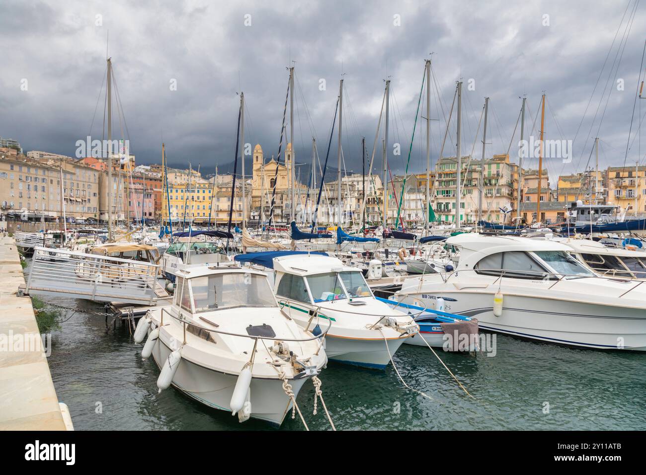 Segel- und Motorboote liegen im Touristenhafen von Bastia, im Hintergrund die Kirche und die Gebäude mit Blick auf den Hafen. Bastia, Haute-Corse, Oberkorsika, Frankreich Stockfoto
