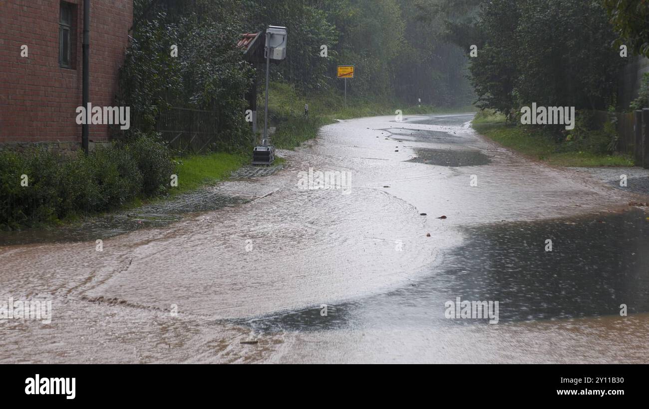 Kräftige Gewitter und Unwetter wüten seit den Nachmittagsstunden im südlichen Niedersachsen. Besonders betroffen sind die Ortschaften Hahausen, Ödishausen und Bodenstein. Über 80 Liter auf dem Quadratmeter ist zu viel für den Boden. Hinzu kommt, dass viele Felder abgeerntet sind. Schlamm ergießt sich über die Straßen und Ortschaften. Vielerorts sind die Feuerwehren im Einsatz. Die Kameraden öffnen Gullys, damit das Wasser abfließen kann. Anwohner haben bereits Sandsäcke an ihren Einfahrten angebracht. Autofahrer wurden von überfluteten Straßen überrascht. Das Wasser Stand teilweise bis zur Mot Stockfoto