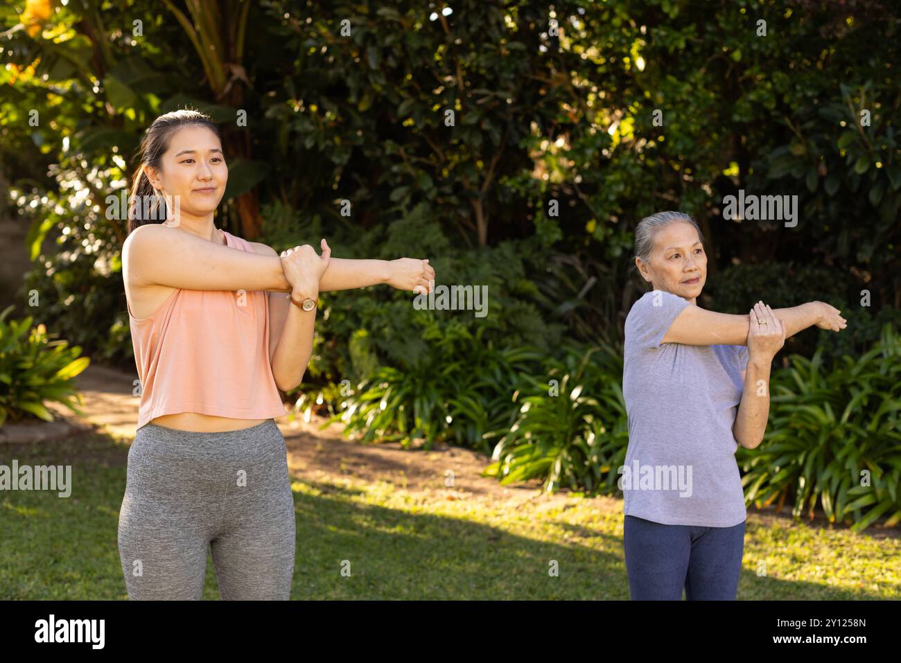 Im Freien trainieren, asiatische Großmutter und Enkelin die Arme Strecken, Fitness-Routine genießen Stockfoto