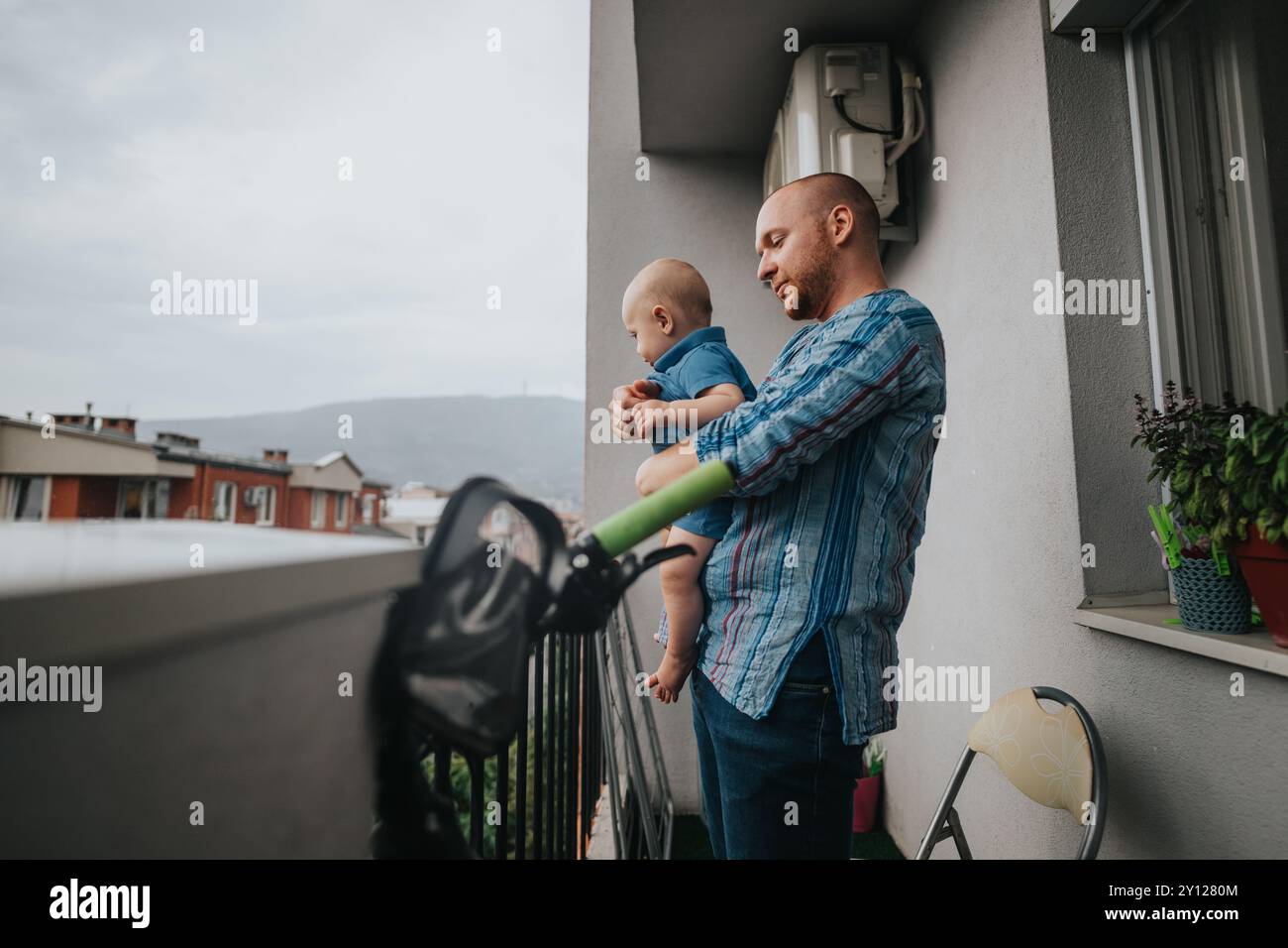 Vater und Baby genießen einen ruhigen Moment auf dem Balkon Stockfoto