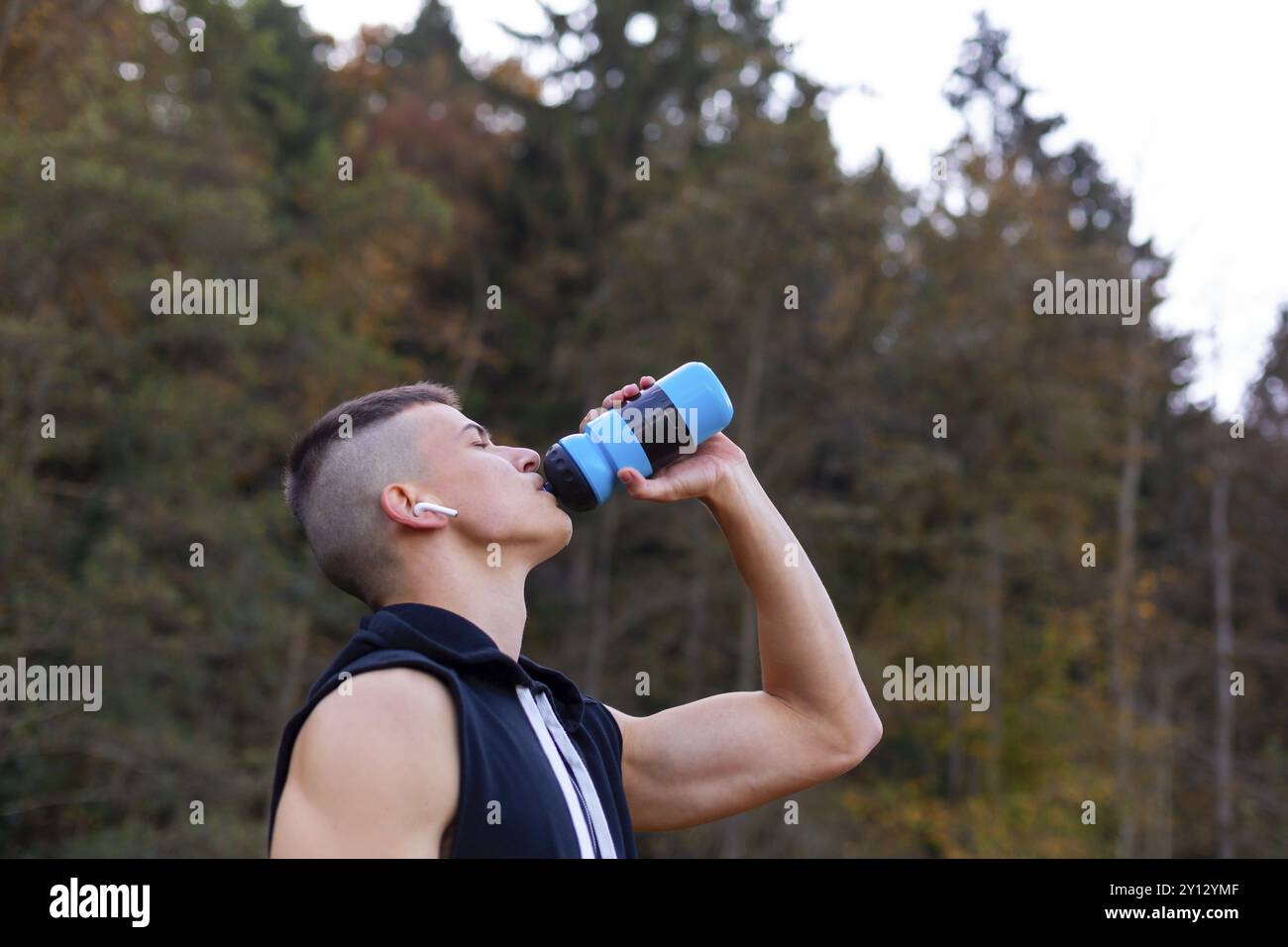 Junger Mann Trinkwasser aus der Flasche beim Joggen am Morgen außerhalb Stockfoto