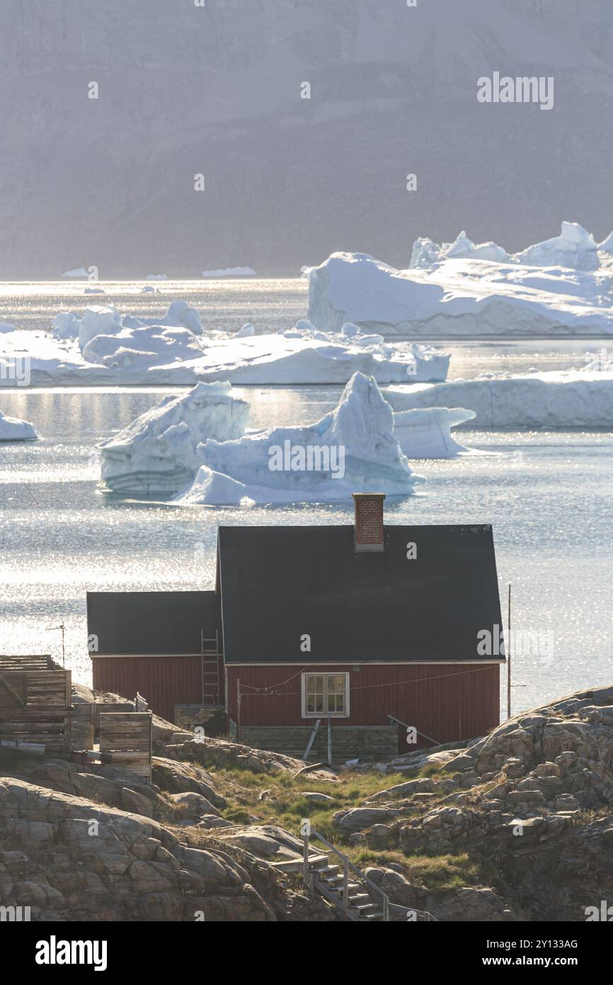 Typisches grönländisches Haus vor Eisbergen am Meer, Sommer, sonnig, Uummannaq, Westgrönland, Grönland, Nordamerika Stockfoto