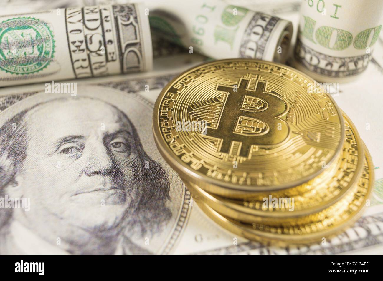 Bitcoin-Stapel und Banknoten von 100 Dollar. Konzeptbild für das globale Blockchain-Zahlungssystem für Kryptowährungen Stockfoto