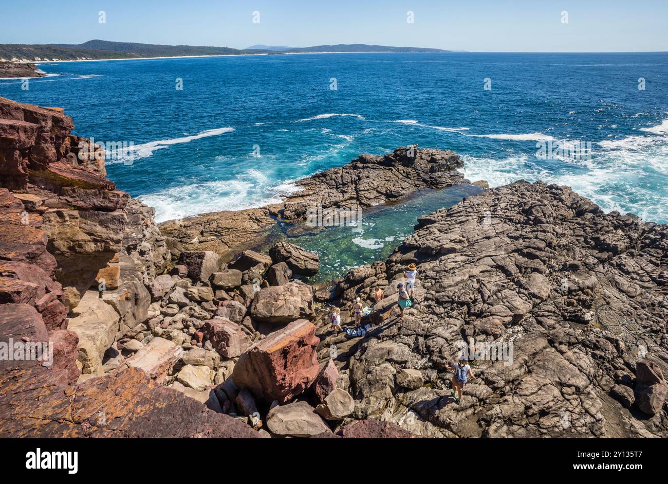 Felsbecken im roten Devon-Felsen am Tura Headland an der Südküste von New South Wales, Australien Stockfoto