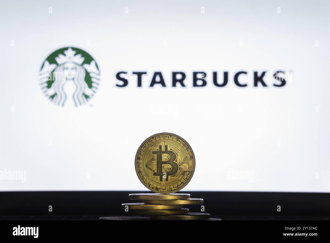 Slowenien, Ljubljana, 02 24 2019: Bitcoin auf einem Stapel Münzen mit Starbucks Logo auf einem Laptop-Bildschirm, Europa Stockfoto