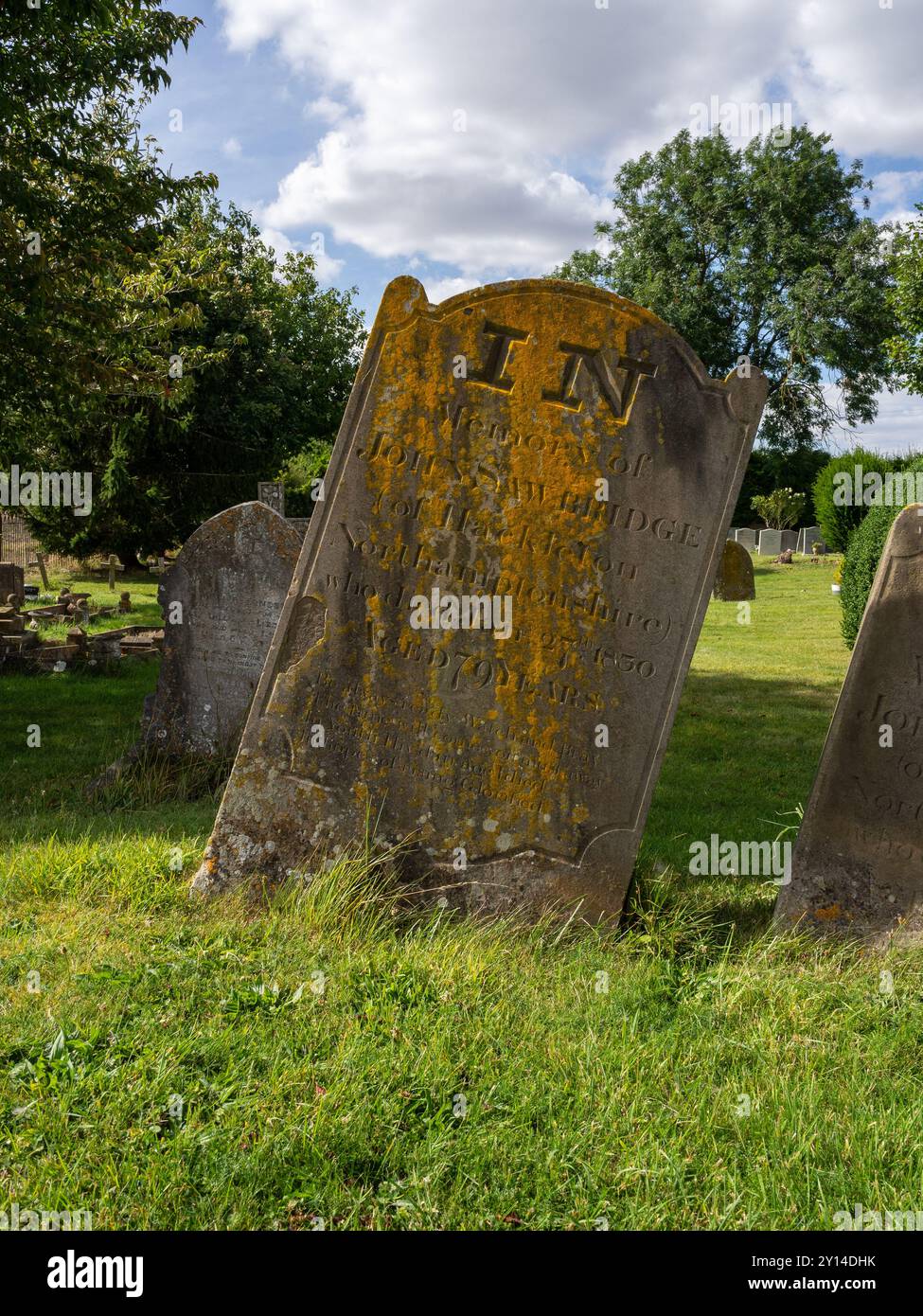 Alter verwitterter, wackeliger Grabstein auf dem Friedhof von St. Peter im Dorf Stoke Goldington, Buckinghamshire, Großbritannien Stockfoto