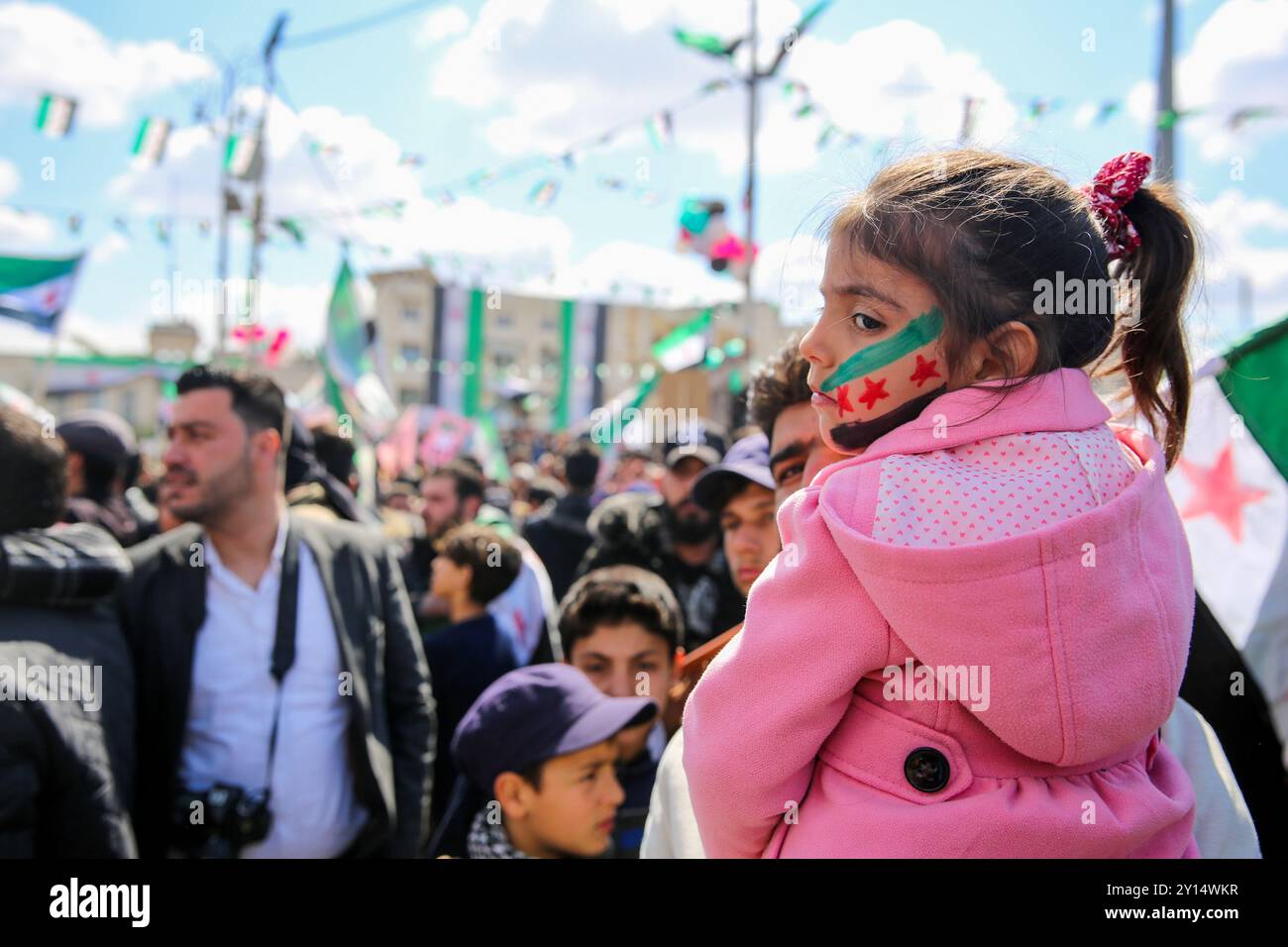 Idlib, Syrien. 15. März 2022. Tausende Demonstranten versammeln sich in der syrischen Stadt Idlib im Nordwesten, um den 11. Jahrestag des syrischen Aufstands zu feiern. Im Norden des Landes fanden zahlreiche Demonstrationen statt, bei denen die Teilnehmer „den Sturz des syrischen Regimes, die Freilassung politischer Gefangener aus dem Gefängnis und die Rückkehr der Vertriebenen“ forderten. Demonstranten hissen auch ukrainische Flaggen in Solidarität mit den Ukrainern und gegen die anhaltende russische Invasion in der Ukraine Stockfoto