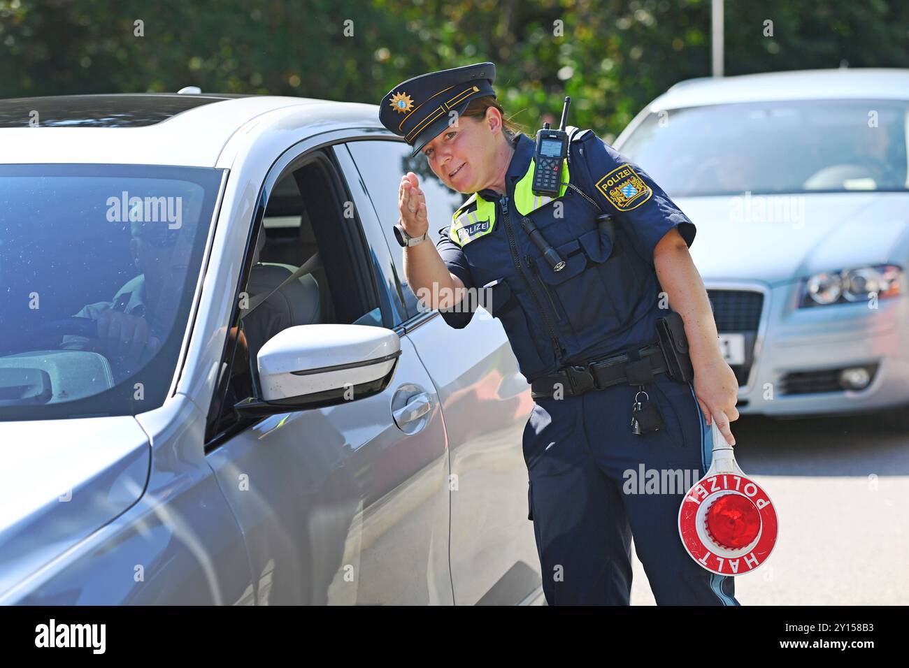 Grenzpolizistin spricht mit einem Fahrer. Grenzpolizisten kontrollieren Fahrzeuge. Joachim HERRMANN (Innenminister Bayerns), Justizminister Georg EISENREICH und die Bayerische Grenzpolizei informieren am 4. September 2024 am Grenzübergang Burghausen „neue Bruecke“ über einen erhöhten Grenzschutz zur Bekämpfung der illegalen Migration. Stockfoto