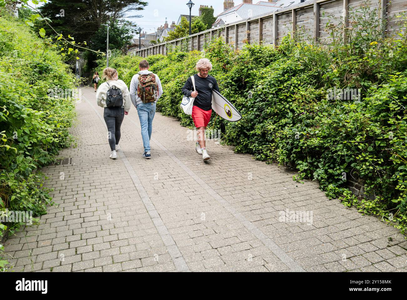 Menschen, die entlang der Fußgängerzone laufen, die einst die historische Route der Straßenbahnlinie im Stadtzentrum von Newquay in Cornwall in Großbritannien war. Stockfoto