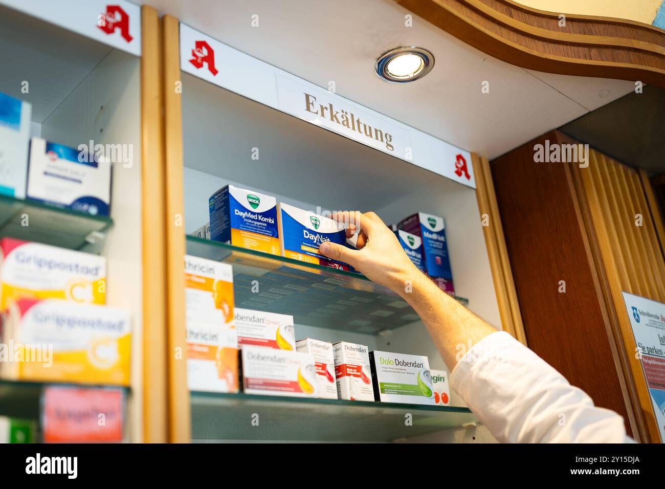 Melle, Deutschland 05. September 2024: Im Bild: In einer Regel einer Apotheke ist das Apothekenlogo und der Schriftzug Erkältung angebracht. Der Apotheker greift nach einem Mittel der Firma Wick, Daynait. Landkreis Osnabrück Niedersachsen *** Melle, Deutschland 05 September 2024 auf dem Bild sind das Apothekenlogo und die Worte Kälte in einer Regel einer Apotheke zu sehen, die der Apotheker für ein Heilmittel von der Firma Wick, Bezirk Daynait Osnabrück Niedersachsen wendet Copyright: XFotostandx/xGelhotx Stockfoto