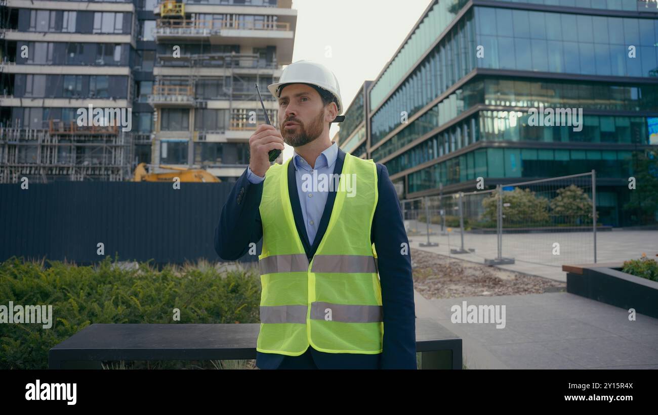 Kaukasischer Baumeister Architekt Ingenieur Auftragnehmer Reparaturarbeiter draußen in der Stadt Sprechen Sie mit Fernfunk Bau Stadtentwicklung Industrie Arbeiter in Stockfoto