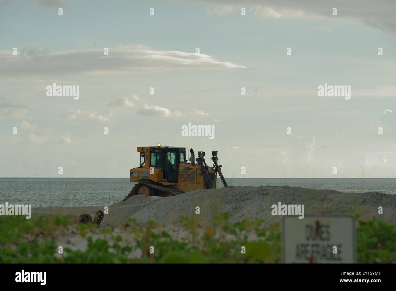 St. Pete Beach, FL in Richtung Golf von Mexiko, da schwere Maschinen an der Strandernährung arbeiten. Blick auf Sand und Hafer. An einem bewölkten Tag spät danach Stockfoto