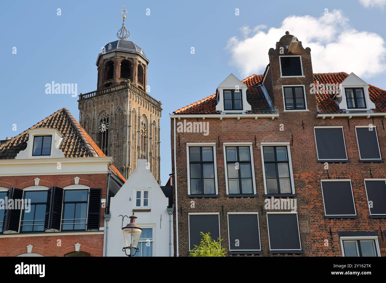 Historische mittelalterliche Häuser am Ufer des Flusses Ijssel in Deventer, Overijssel, Niederlande, mit dem Glockenturm der Lebuinus-Kirche Stockfoto