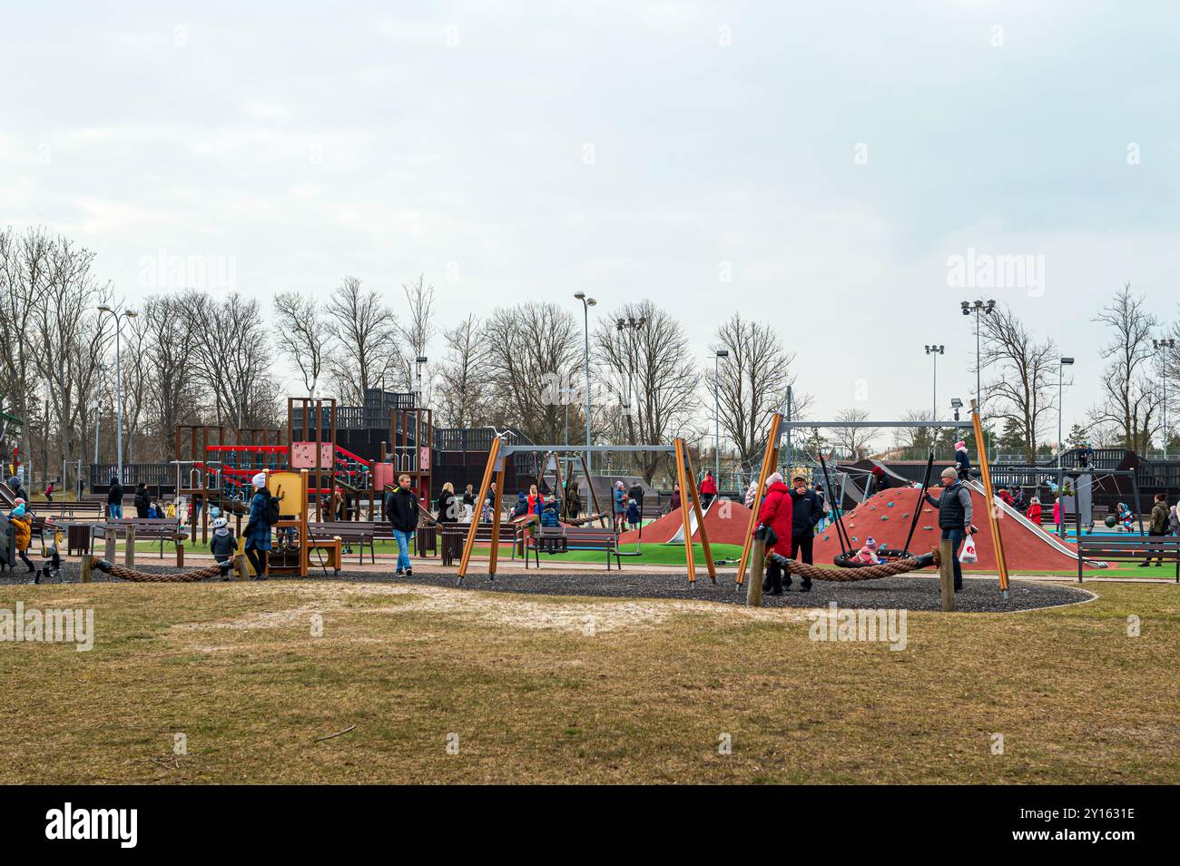 Liepaja, Lettland - 19. März 2023: Familien treffen sich an einem Frühlingnachmittag in einem Gemeinschaftspark zum Spielen und Sozialisieren. Stockfoto