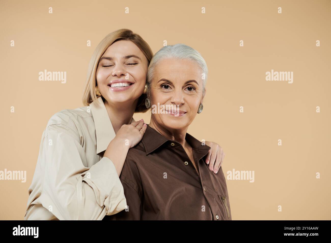 Eine reife Frau und ihre erwachsene Tochter lächeln strahlend und feiern ihre Bindung. Stockfoto