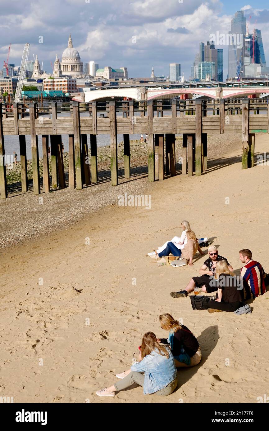 Menschen am Sandstrand, der bei Flut am Southufer der Themse im Zentrum von London, Großbritannien, ausgesetzt ist. Stockfoto