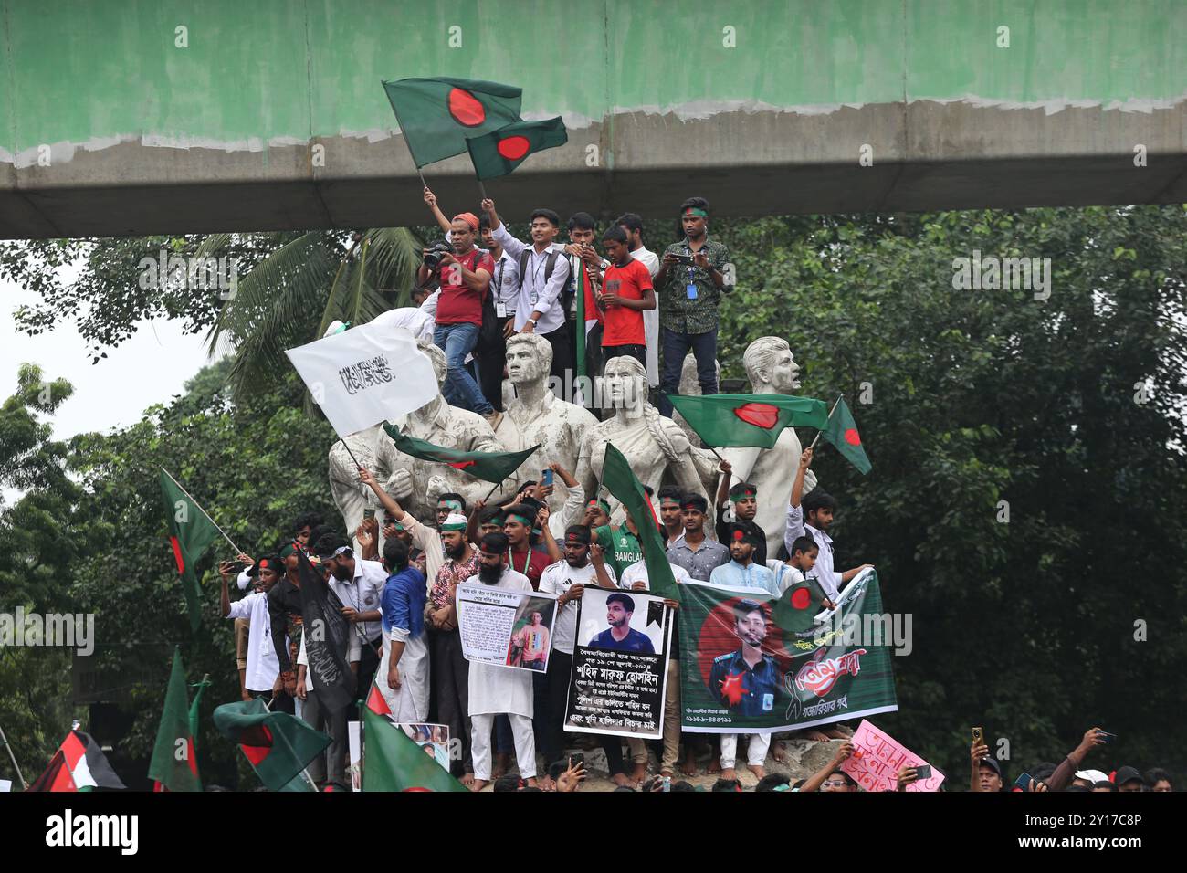 Dhaka, Wari, Bangladesch. September 2024. Demonstranten schwenken Bangladeschs Nationalflagge während des Märtyrermarsches, einer von Studenten organisierten Demonstration gegen Diskriminierung, um einen Monat nach dem Sturz des ehemaligen Premierministers Sheikh Hasina in Dhaka am 5. September 2024 zu feiern. Bangladeschs gestürzter Premierminister Scheich Hasina sollte im Exil in Indien „ruhig bleiben“, bis sie zum Prozess nach Hause gebracht wird, sagte der Interimsführer Muhammad Yunus den indischen Medien am 5. September. Hasina, 76 Jahre alt, floh vor einem Monat mit dem Hubschrauber nach Indien, als Demonstranten in ihrem Palast marschierten, um ihre Herrschaft mit eiserner Faust zu beenden Stockfoto