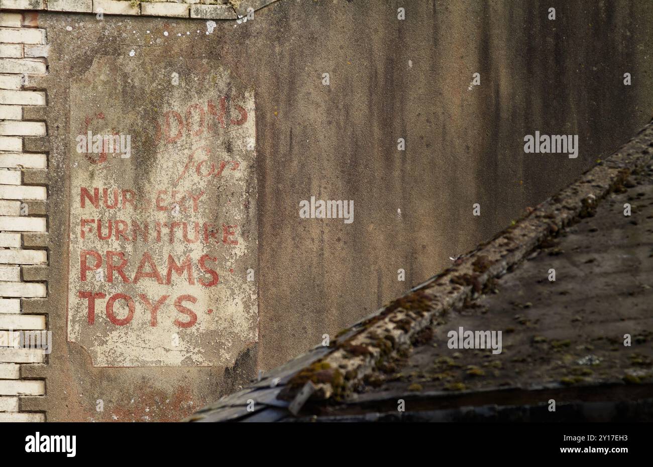 Altes, verblasstes, abgenutztes, gemaltes Werbesild an der Seite Eines Gebäudes für Gladdons Toys, Sidmouth, Großbritannien Stockfoto