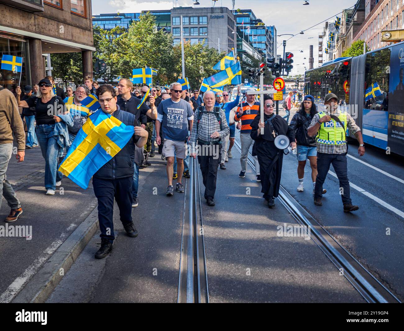 Stockholm, Schweden - 24. August 2024: Eine Gruppe von Personen, die schwedische Fahnen halten, demonstriert auf der Hamngatan in für westliche Werte und gegen den Islam Stockfoto