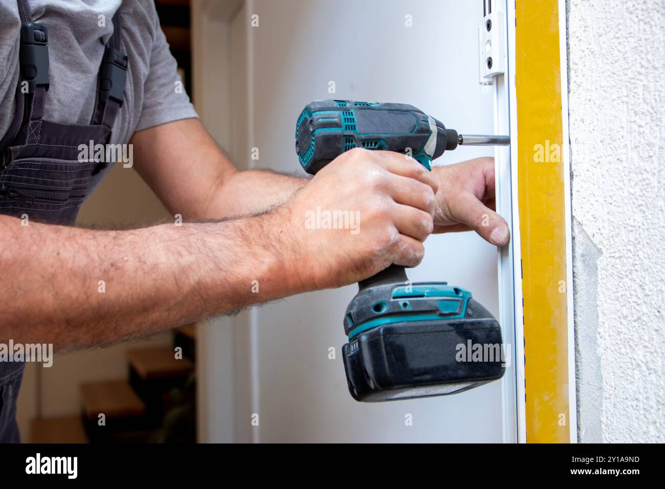 Professionelle Zimmerleute installieren eine Eingangstür in einer neuen Wohnung. Der Türmonteur hat den alten durch einen neuen ersetzt Stockfoto