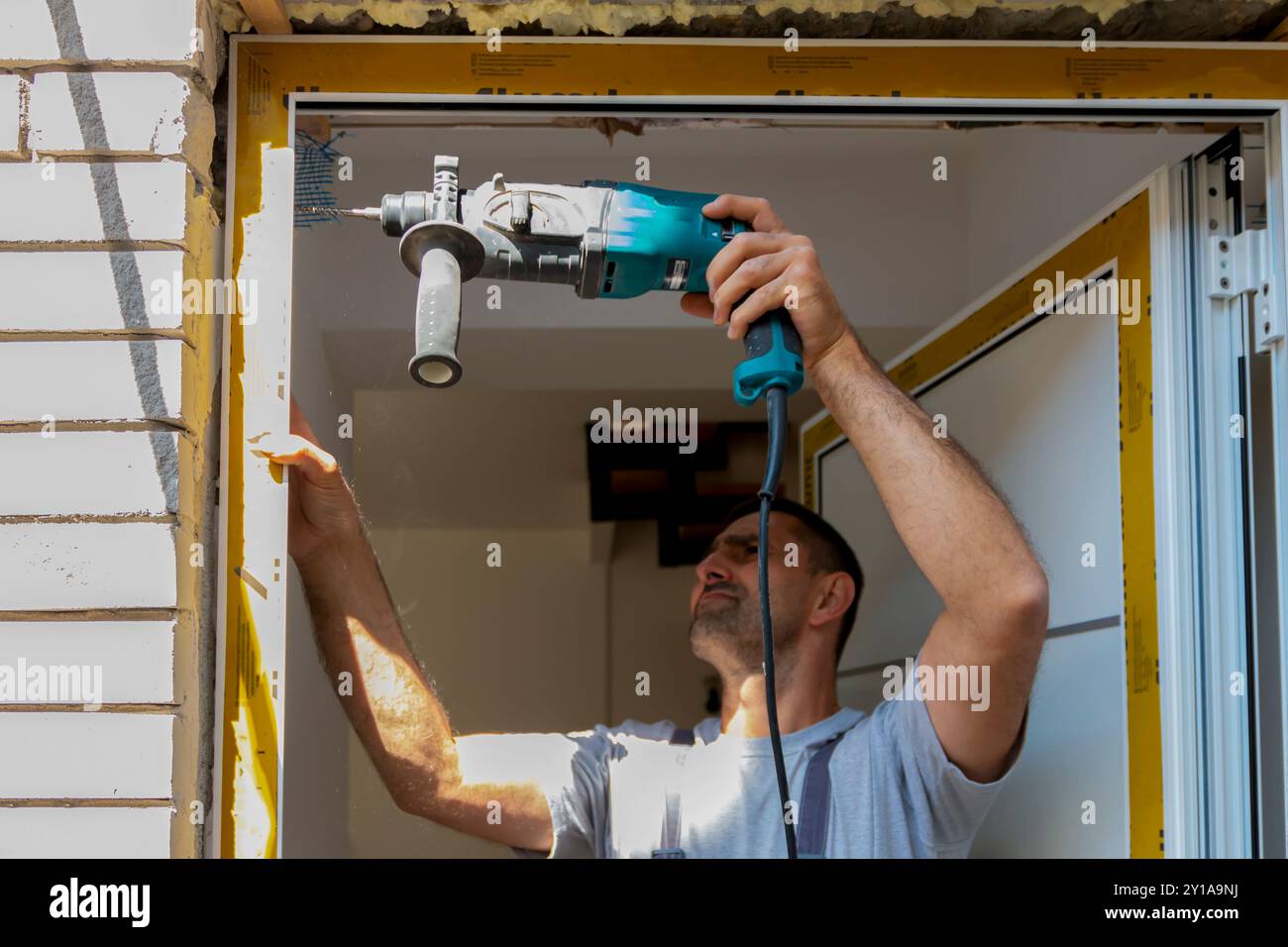 Professionelle Zimmerleute installieren eine Eingangstür in einer neuen Wohnung. Der Türmonteur hat den alten durch einen neuen ersetzt Stockfoto