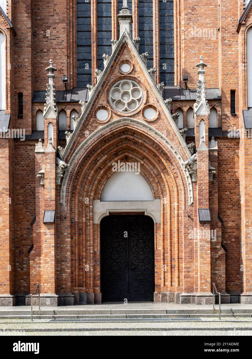 Haupteingang der Kirche aus rotem Backstein im neogotischen Stil. Stockfoto