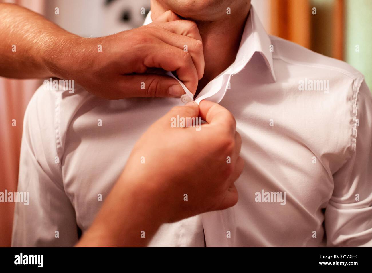 Knöpfen Sie ein weißes Hemd für formelle Anlässe mit den Händen. Stockfoto