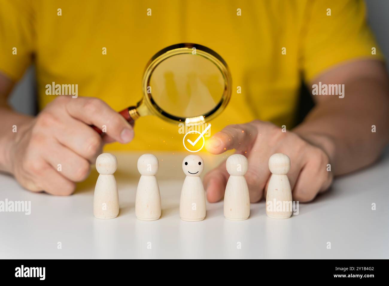 Personalwesen (HR), Einstellung, Auswahl, Rekrutierung, CRM, richtige Personen und einzigartige Konzepte. Menschliche Hand, Die Lupe Über Holzfiguren Hält. Stockfoto