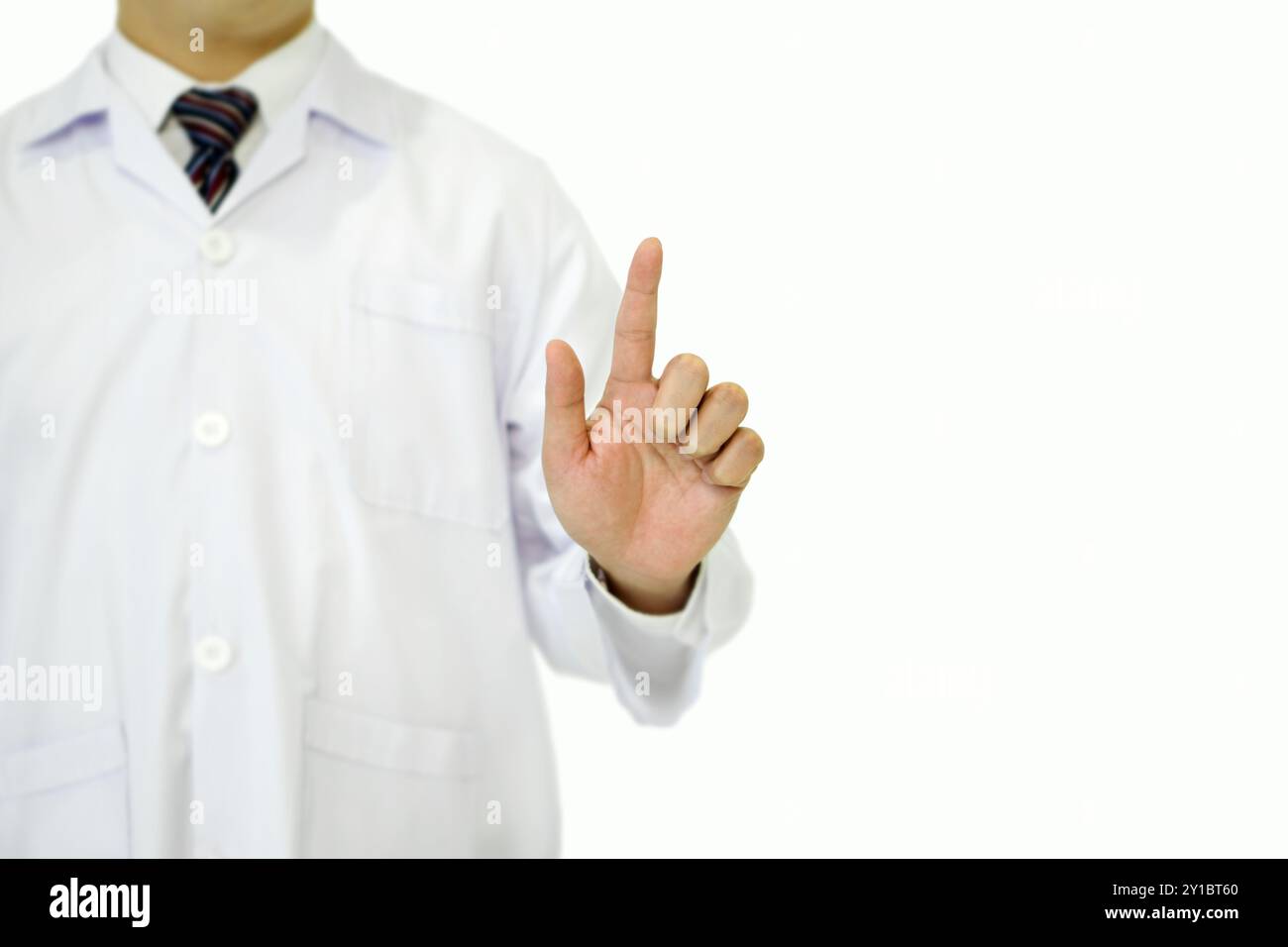 Ein Arzt in einem weißen Labormantel, der mit der Hand auf den Finger zeigt. Porträt auf weißem Hintergrund, Studioaufnahme. Stockfoto