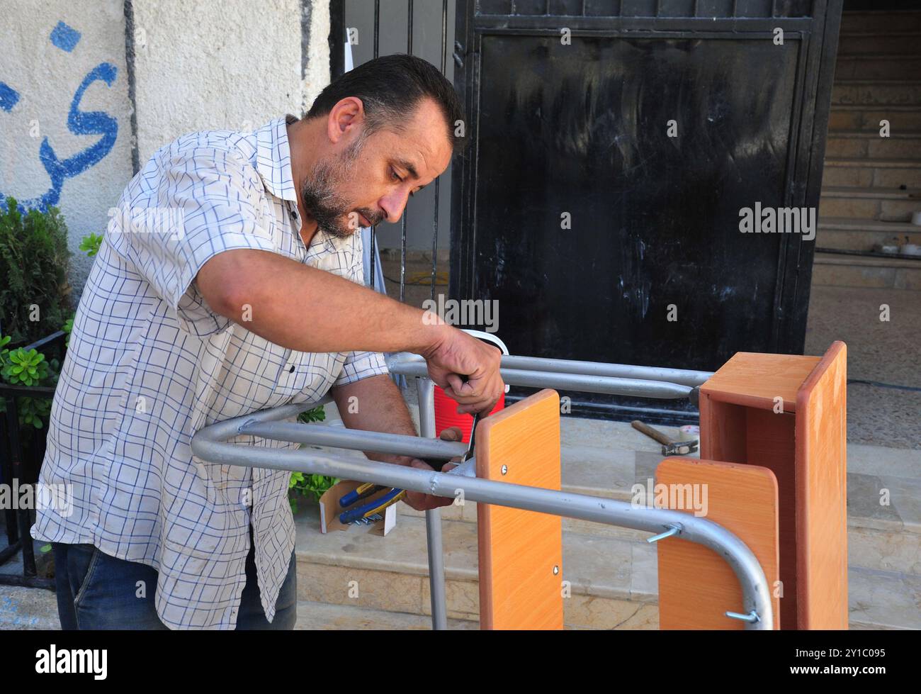 Damaskus, Syrien. September 2024. Ein Mann arbeitet an einem Schulpult in Ost-Ghouta, östlich von Damaskus, Syrien, 5. September 2024. Quelle: Ammar Safarjalani/Xinhua/Alamy Live News Stockfoto