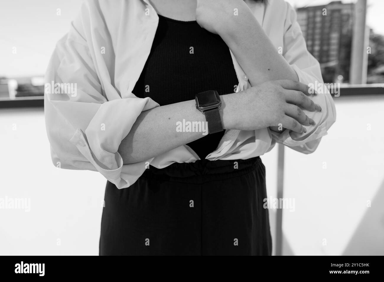 Moderner Stil und Eleganz: Frau trägt Smartwatch in Schwarz-weiß-Komposition. Stockfoto