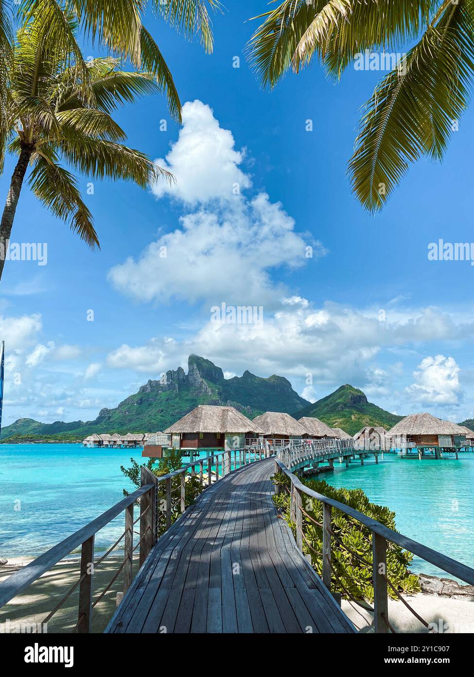 Blick auf den Mount Otemanu durch türkisfarbene Lagune, Palmen und Überwasser-Bungalows auf Bora Bora Island, Tahiti, Französisch-Polynesien und Südpazifik Stockfoto