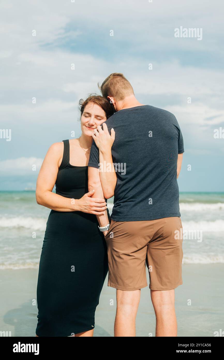 Ein Paar, das sich am Strand umgibt und Liebe und Zufriedenheit ausstrahlt Stockfoto