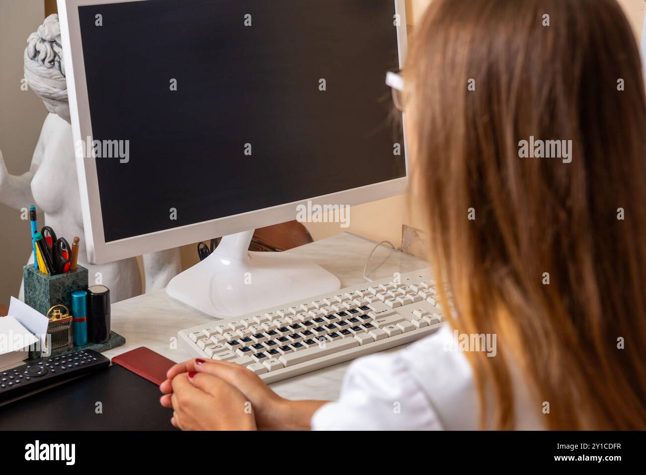 Ein ruhiger und ruhiger Arbeitsbereich mit Computer, Schreibwaren und verschiedenen künstlerischen Elementen Stockfoto